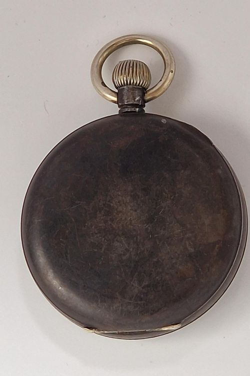 fig 1. An open-face pocket watch featuring a white enamel dial, black Roman numerals, a subsidiary seconds dial, and a metallic case with a top winding crown.
