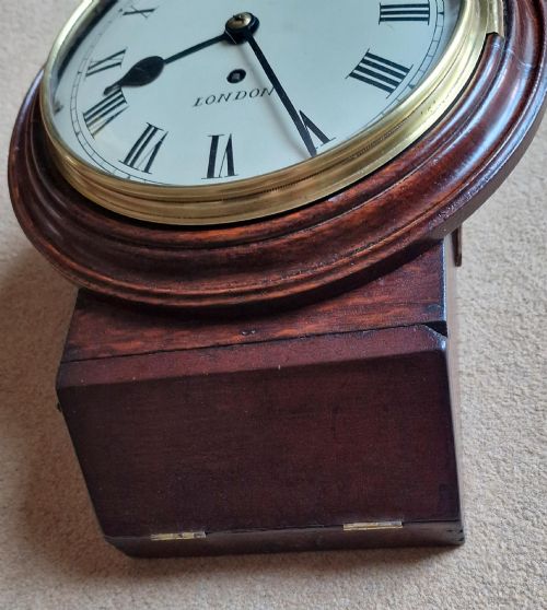 fig 1. An antique wall clock featuring a circular white dial marked Short London with Roman numerals, housed in a moulded mahogany wooden casing with a brass-framed glass bezel.