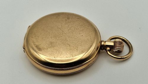 fig 1. A gold-coloured half-hunter pocket watch featuring an outer case with black Roman numerals around a central glass viewing aperture.