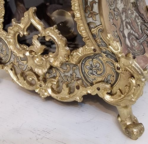 fig 2. A French Rococo revival Boulle inlaid mantel clock featuring gilt brass mounts, blue Roman numerals on white enamel cartouches, and a cherub finial.