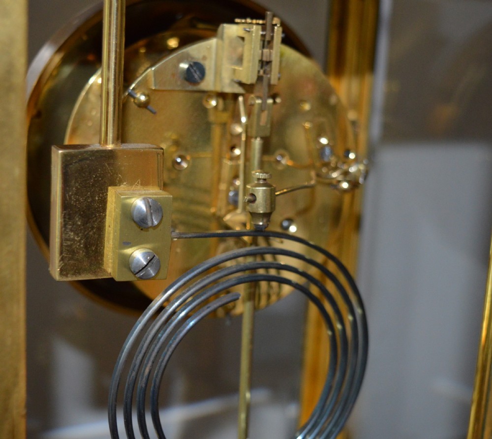 A French four-glass mantel clock framed in brass and black slate flanked by two matching brass candlesticks. View VIII