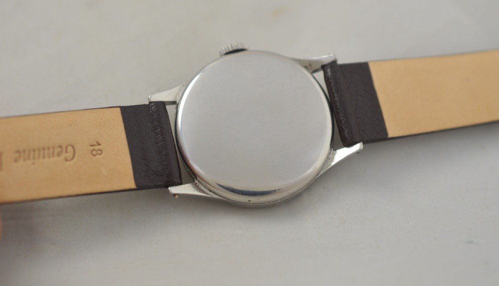 A 1951 Longines gentlemans mechanical wristwatch with a circular stainless steel case, cream dial featuring sub-seconds, and a dark brown leather strap. View II