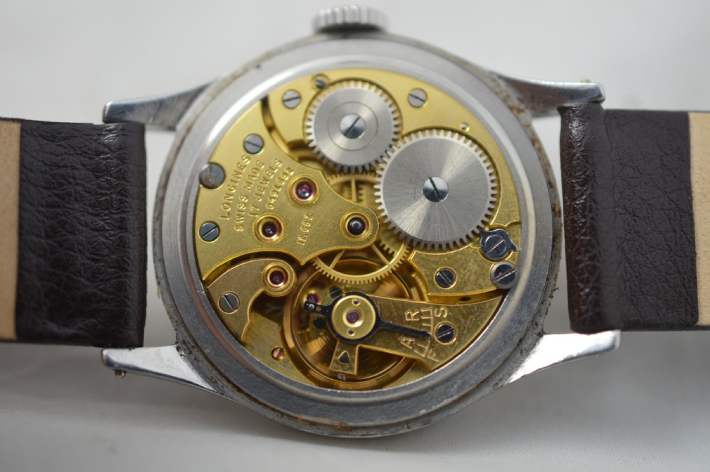 A 1951 Longines gentlemans mechanical wristwatch with a circular stainless steel case, cream dial featuring sub-seconds, and a dark brown leather strap. View VI