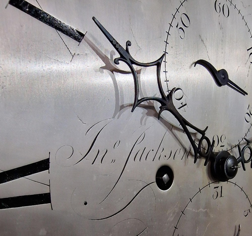 An 18th-century Georgian mahogany longcase clock with an arched silvered brass dial, fluted hood columns, and three brass ball-and-spire finials. View IV