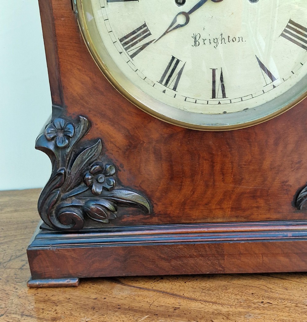 A Victorian carved mahogany fusee bracket clock featuring a circular white dial with Roman numerals inscribed Edw. Funnell Brighton within a brass bezel. View V