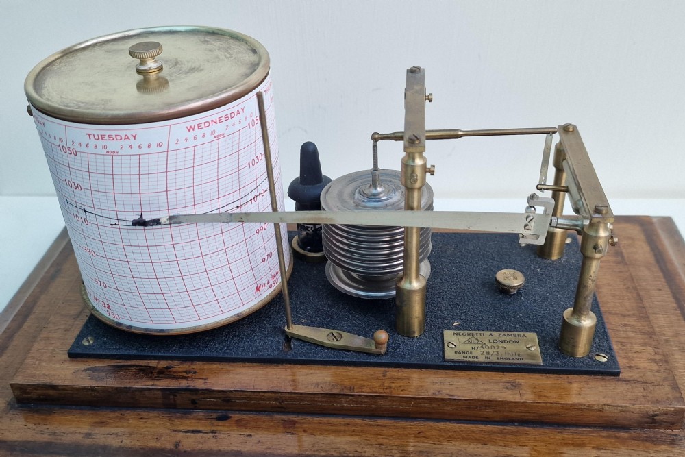 An antique Negretti and Zambra barograph featuring a brass recording mechanism and paper chart drum inside a glazed oak display case. View II