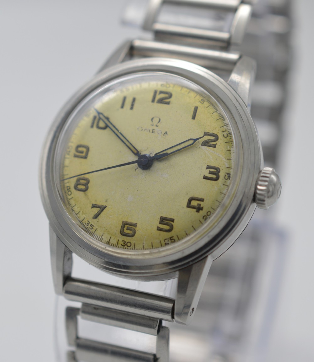 A 1944 Omega military-style wristwatch featuring a patinated cream dial, black Arabic numerals, dark hands, a stainless steel case, and a flexible metal bracelet. View II