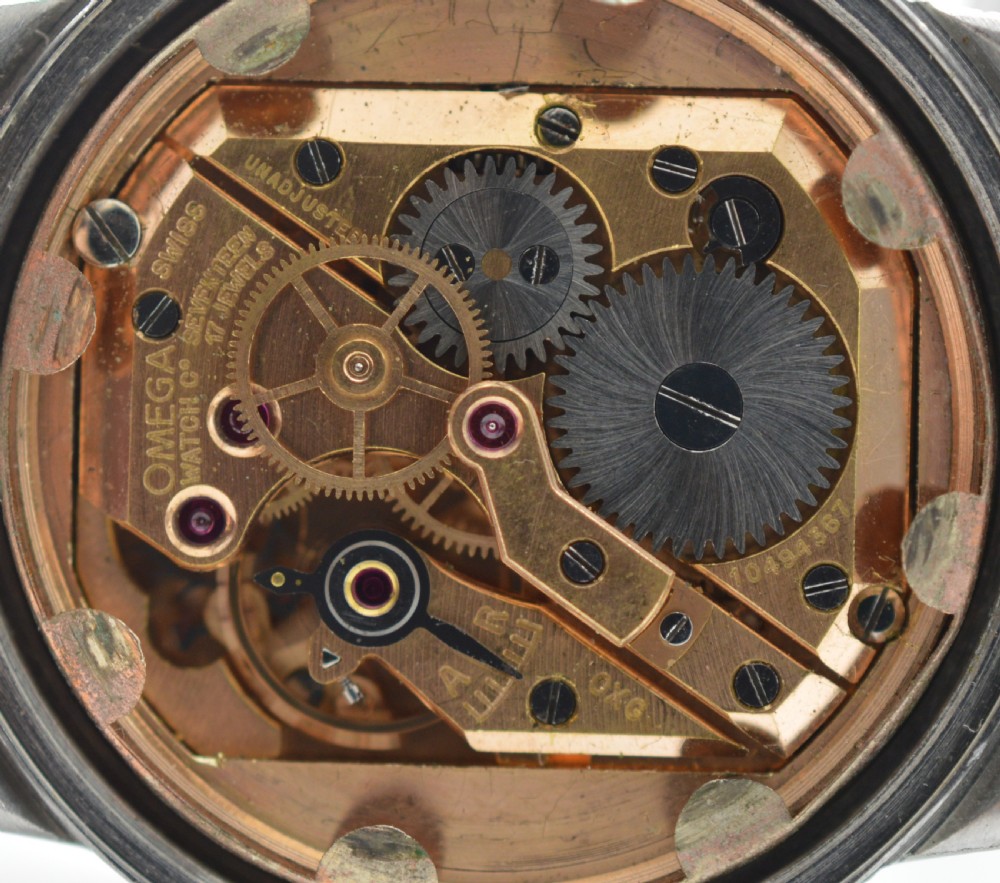 A 1944 Omega military-style wristwatch featuring a patinated cream dial, black Arabic numerals, dark hands, a stainless steel case, and a flexible metal bracelet. View VI