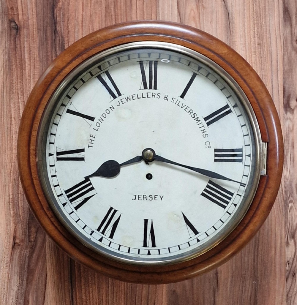 A circular mahogany fusee wall clock featuring a white painted dial with Roman numerals, black hands, and a brass bezel surround.