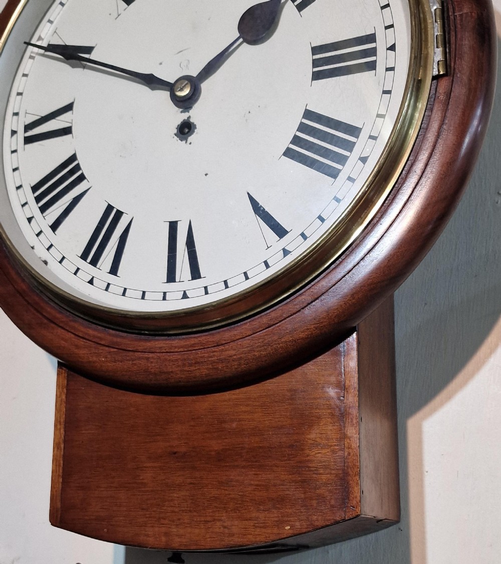 An antique George V mahogany drop dial wall clock featuring a circular painted dial with black Roman numerals and a brass bezel. View II