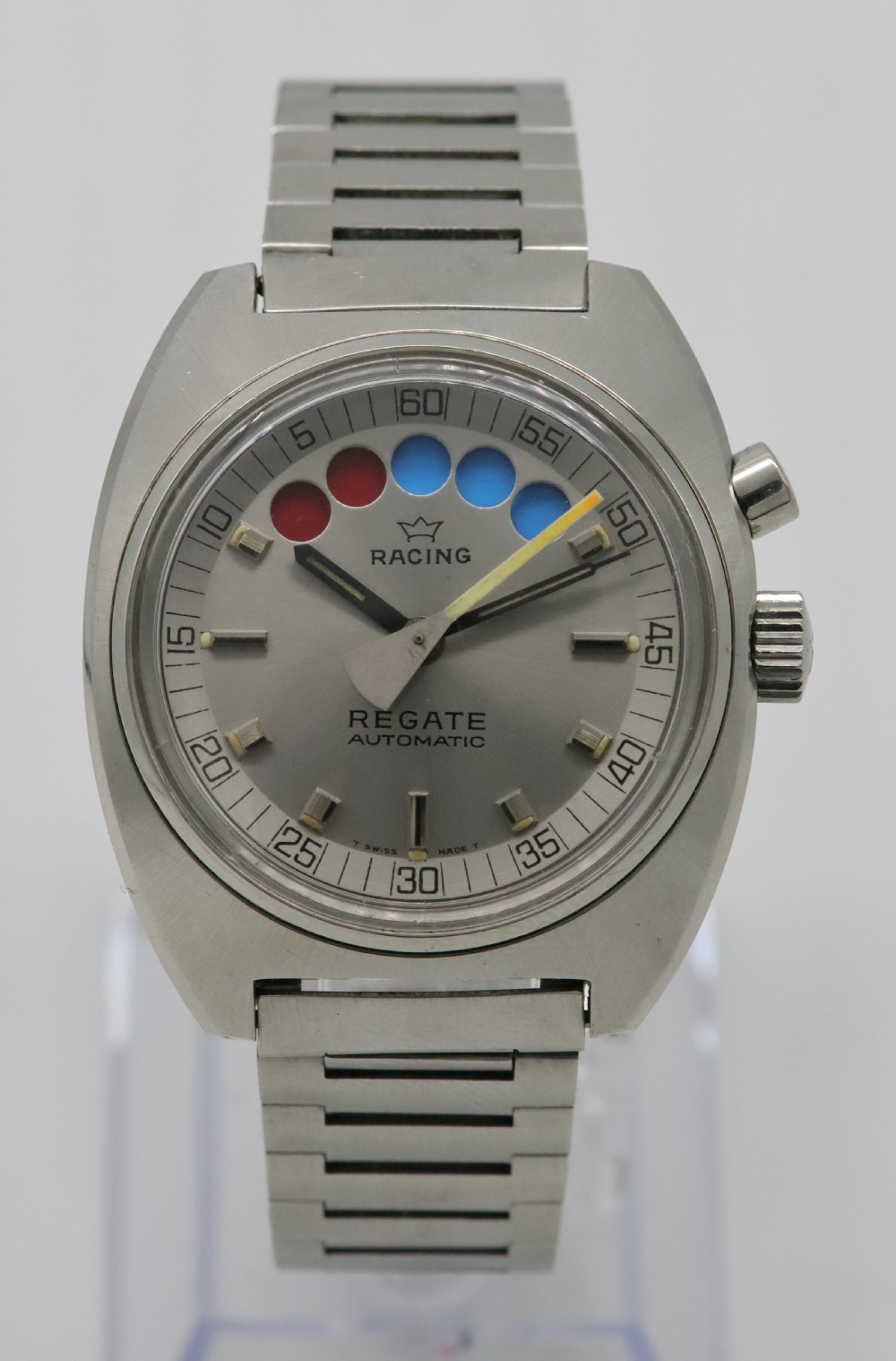 A 1970s Aquastar Regate vintage yacht racing watch featuring a stainless steel cushion case, integrated steel bracelet, and a silver dial with five regatta timer apertures.