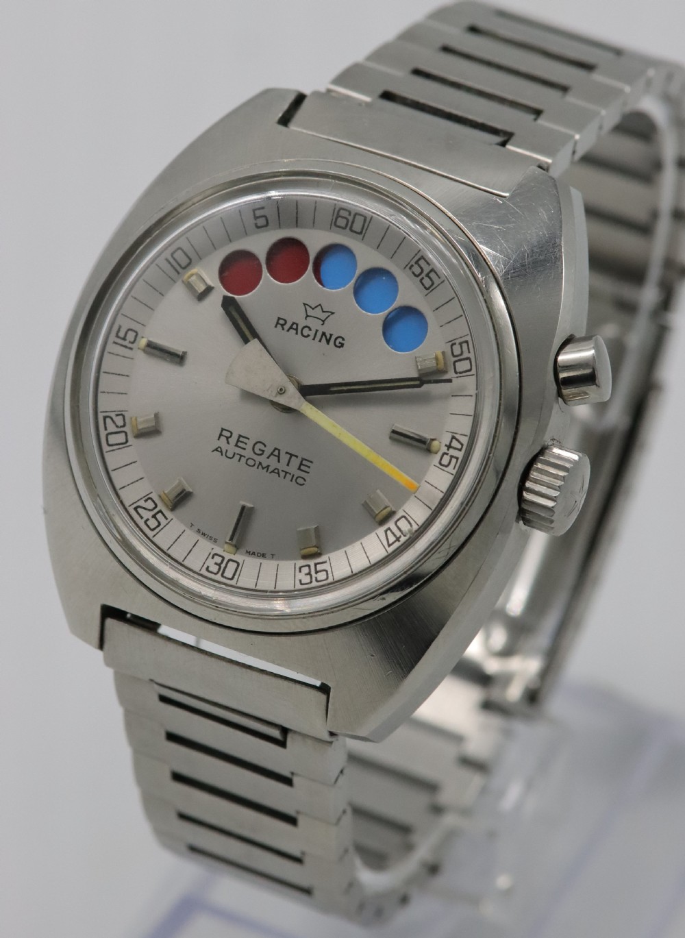 A 1970s Aquastar Regate vintage yacht racing watch featuring a stainless steel cushion case, integrated steel bracelet, and a silver dial with five regatta timer apertures. View II