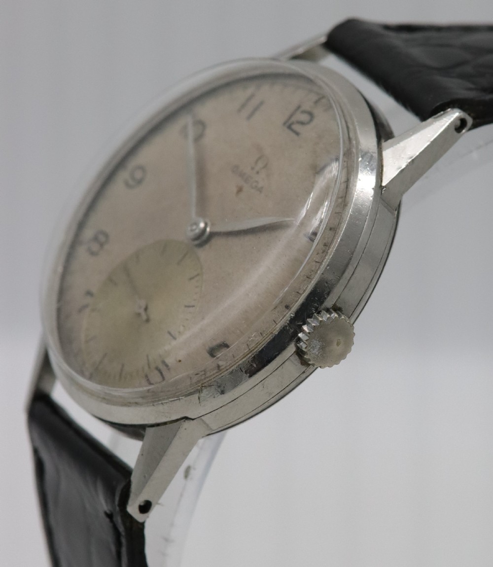 A 1944 vintage Omega Teddington wristwatch featuring a circular silver-tone dial with Arabic numerals, a sub-seconds register, a small red star emblem, and a black leather strap. View III