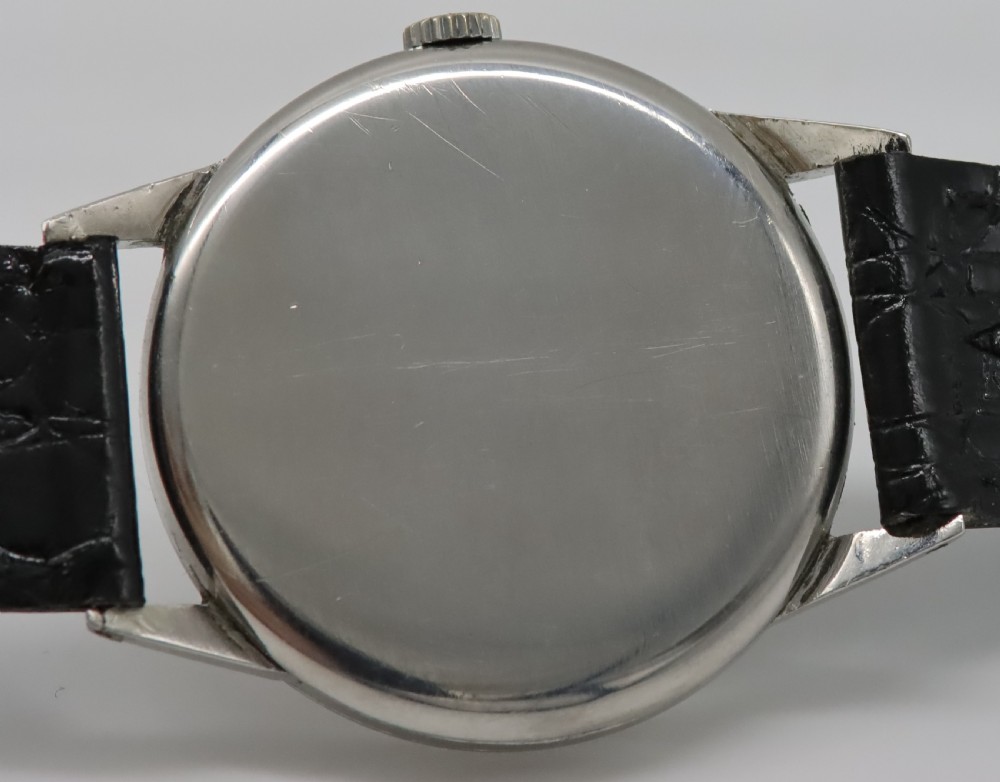 A 1944 vintage Omega Teddington wristwatch featuring a circular silver-tone dial with Arabic numerals, a sub-seconds register, a small red star emblem, and a black leather strap. View V