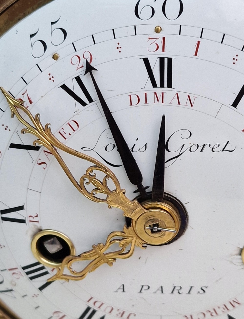 An antique Louis XVI style white marble and gilt bronze mantel clock featuring a calendar enamel dial and floral garland mounts. View II