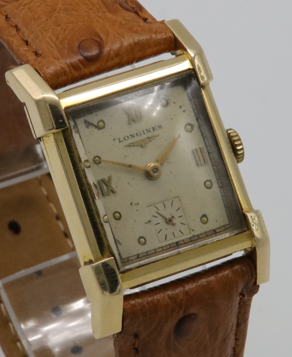 A 1949 Longines rectangular 14k gold wristwatch featuring a cream dial with sub-seconds register and a tan leather strap. View VIII