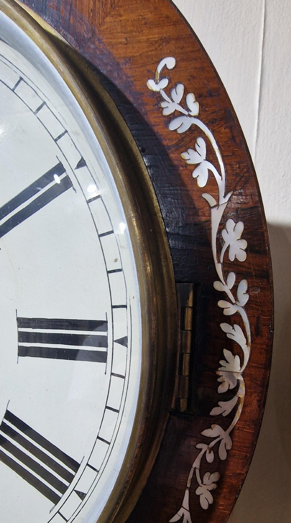 A Victorian mahogany drop dial wall clock featuring mother-of-pearl inlay, carved scroll sides, a brass bezel, and a white dial signed Chave Taunton with Roman numerals. View III