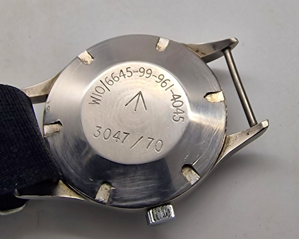 A Smiths W10 military wristwatch featuring a black dial with Arabic numerals, broad arrow mark, and a black strap. View III