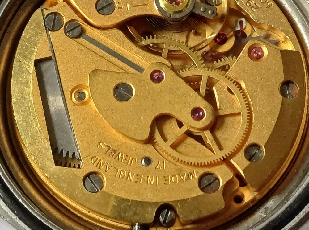A Smiths W10 military wristwatch featuring a black dial with Arabic numerals, broad arrow mark, and a black strap. View IV