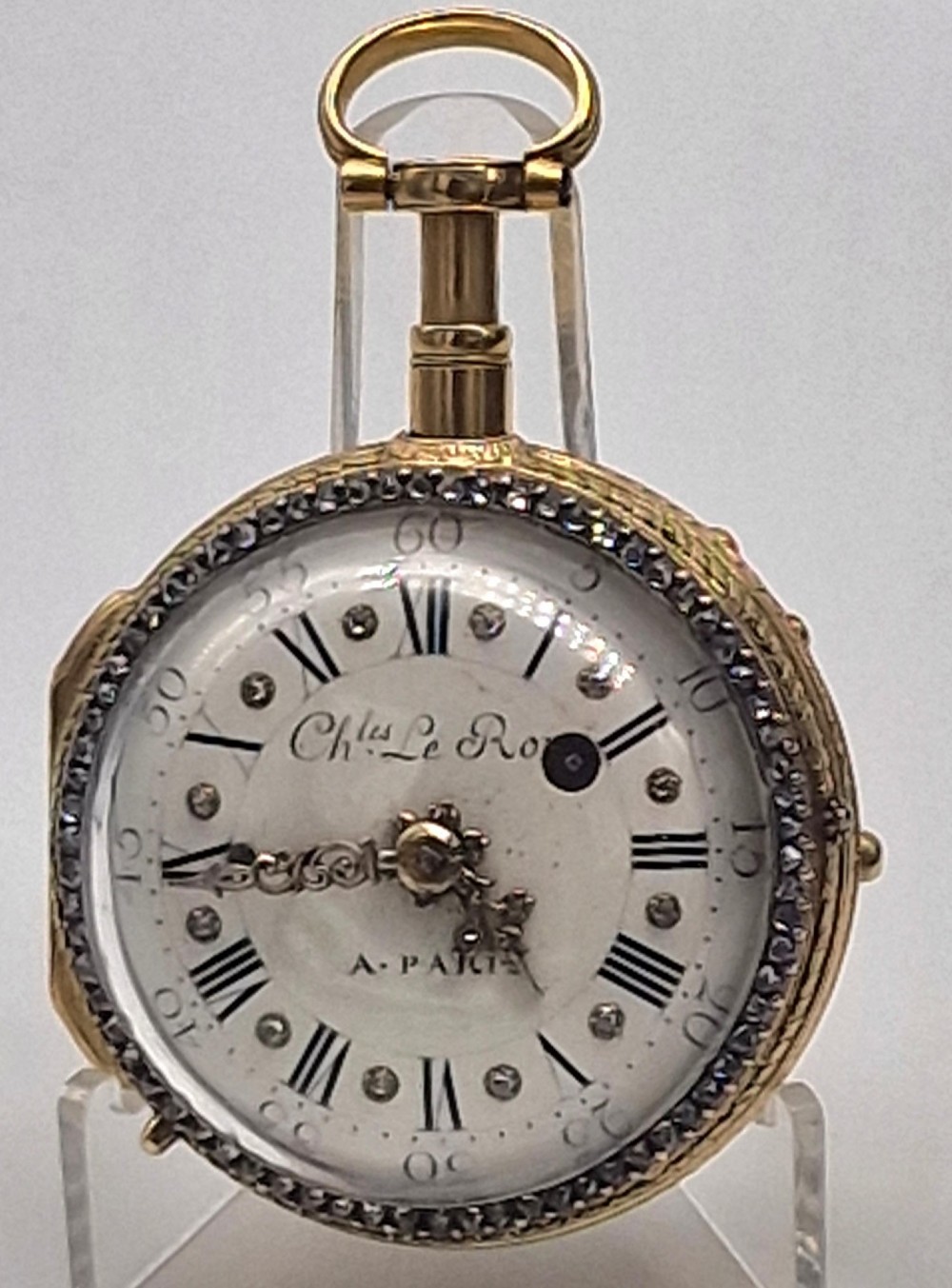 An eighteenth-century French gold quarter repeating pocket watch featuring a white enamel dial with Roman numerals, ornamental hands, and a jewel-encrusted bezel.