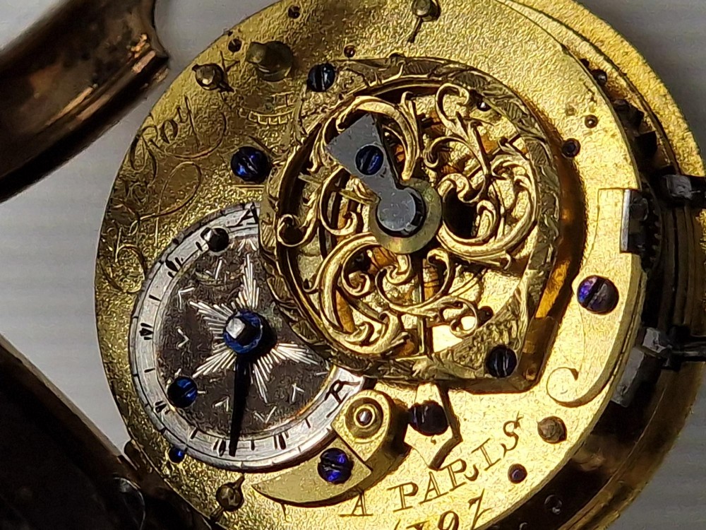 An eighteenth-century French gold quarter repeating pocket watch featuring a white enamel dial with Roman numerals, ornamental hands, and a jewel-encrusted bezel. View V