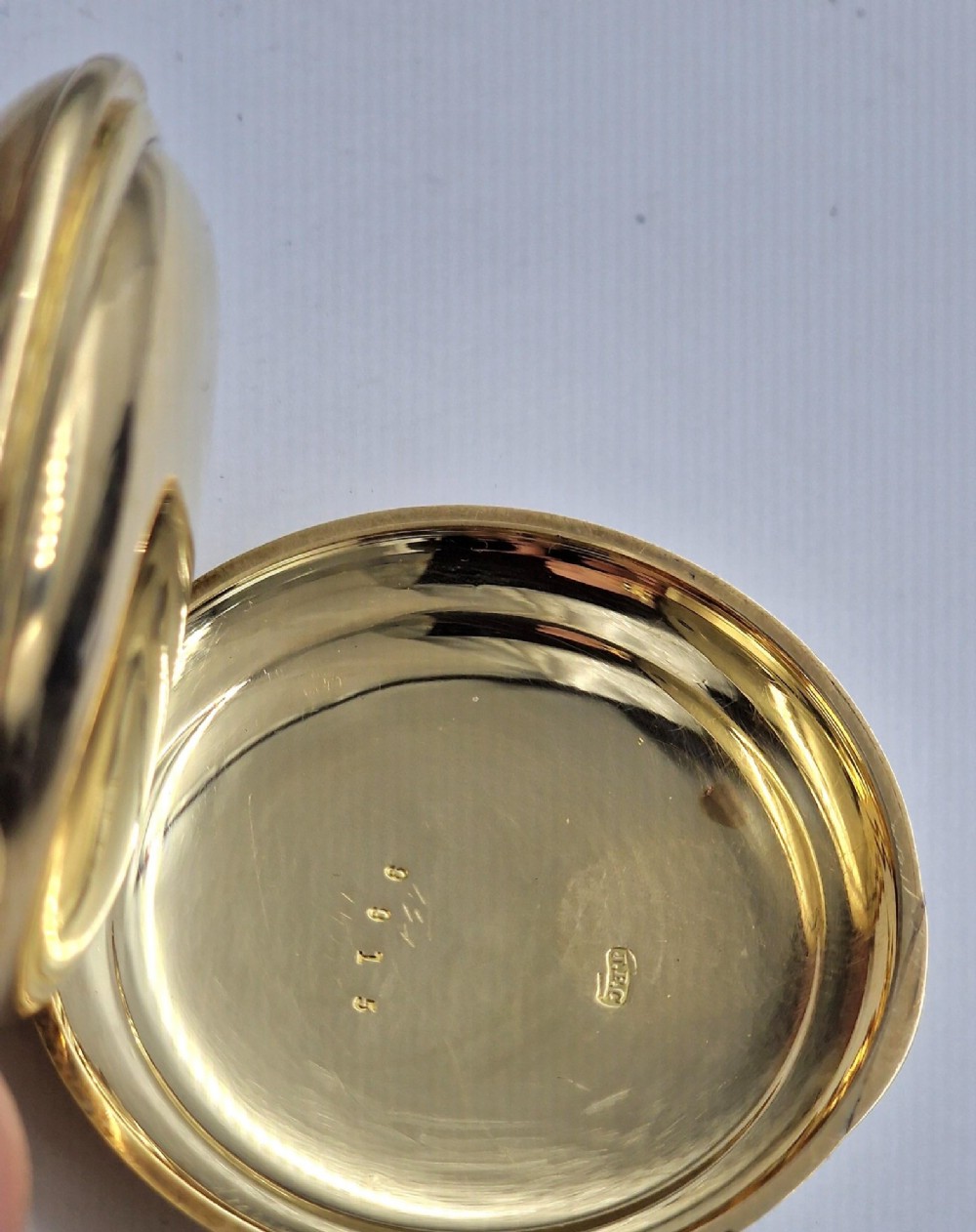 A 14k yellow gold full hunter pocket watch displayed with its cover open to show a white enamel dial with black Roman numerals and a subsidiary seconds sub-dial. View IV