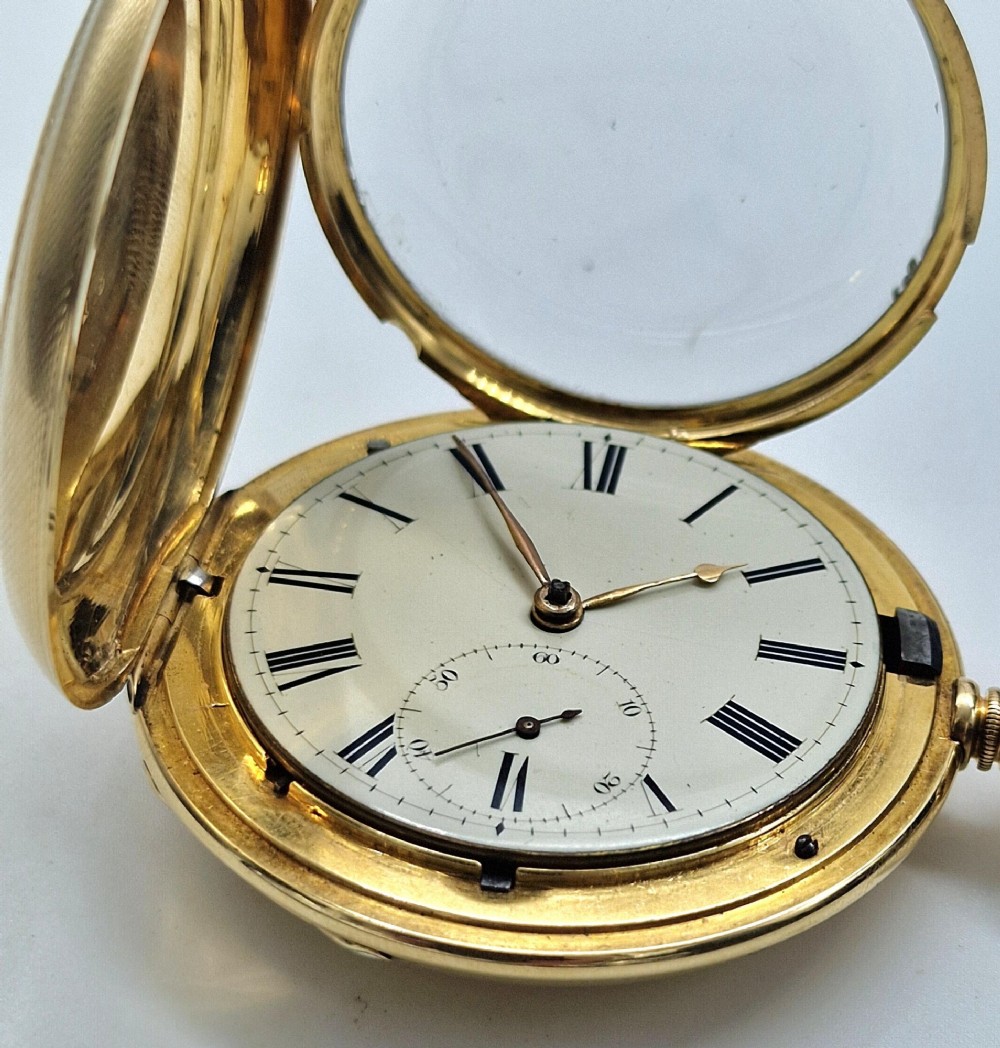 A 14k yellow gold full hunter pocket watch displayed with its cover open to show a white enamel dial with black Roman numerals and a subsidiary seconds sub-dial. View VIII