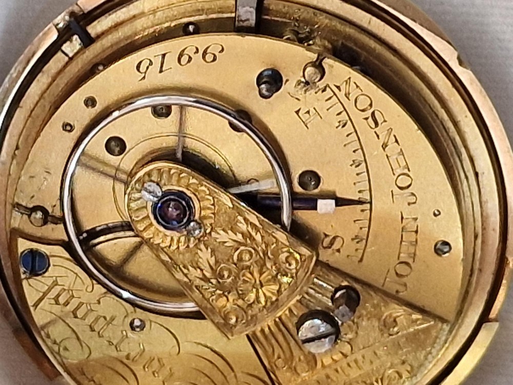 A 14k yellow gold full hunter pocket watch displayed with its cover open to show a white enamel dial with black Roman numerals and a subsidiary seconds sub-dial. View X