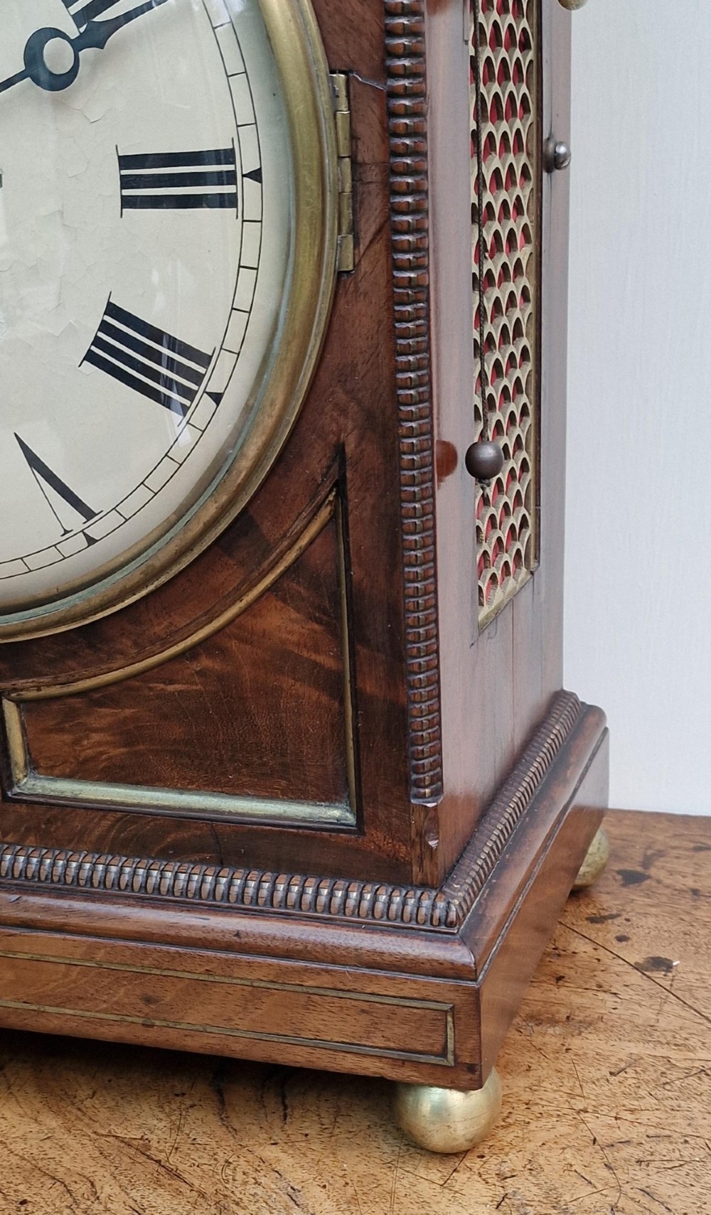 A Regency mahogany bracket clock featuring a white circular dial signed Thomas Jackson London, framed by brass stringing, lion head side handles, and a pineapple finial. View III