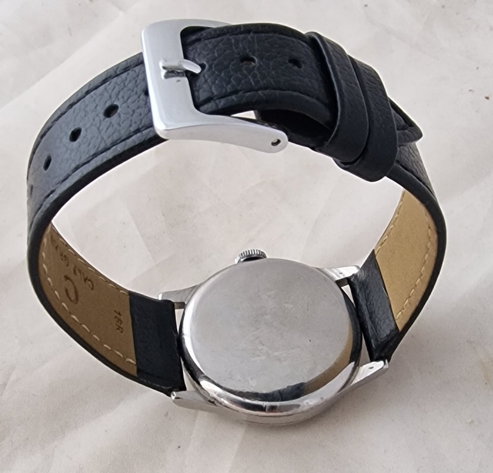 A vintage 1944 Omega wristwatch featuring a circular stainless steel case, black dial with Arabic numerals, sub-seconds dial, and a black leather strap. View II