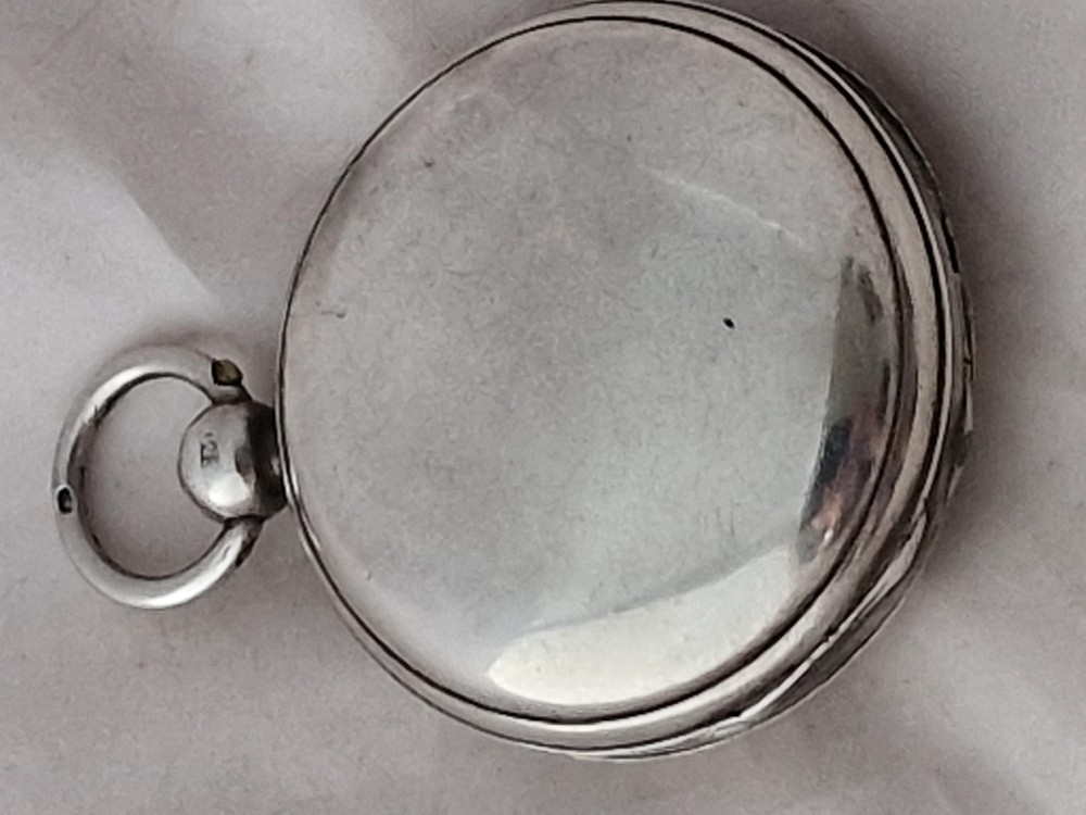 An open silver hunter pocket watch featuring a white enamel dial with black Arabic numerals and a silver hinged case. View II