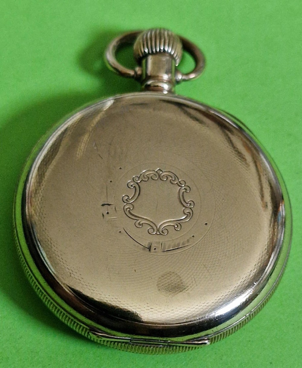 An open-face gold-toned pocket watch featuring a white enamel dial with black Arabic numerals, blued steel hands, and a subsidiary seconds sub-dial at six oclock. View IV