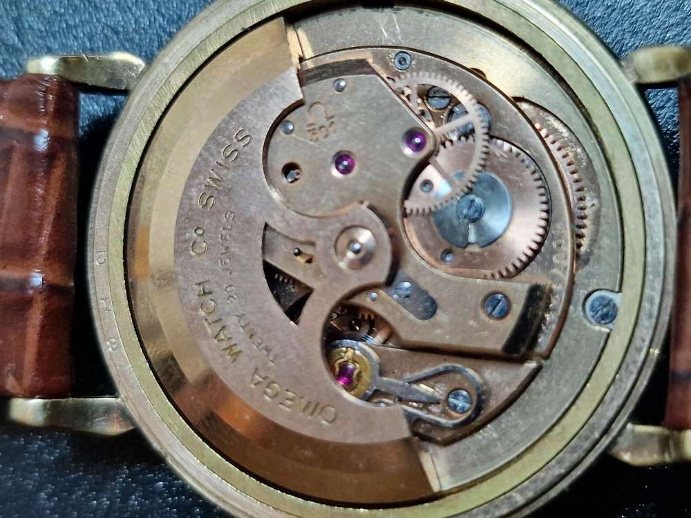 A 1950s vintage Omega automatic wristwatch crafted with a 9K gold case and brown leather strap, set inside a red presentation box. View VIII