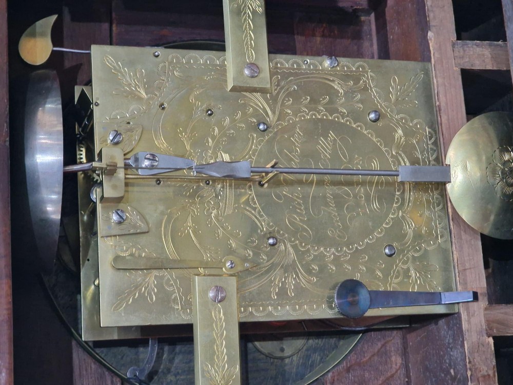 A Georgian flame mahogany bracket clock featuring a brass carrying handle, circular white dial with Roman numerals, and brass-backed side frets. View VIII