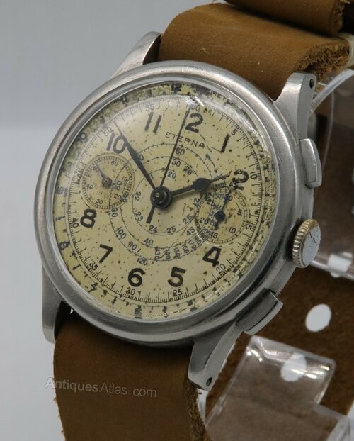 A vintage 1930s Eterna chronograph wristwatch with a patinated cream dial, two sub-dials, stainless steel case, and brown leather strap. View VI