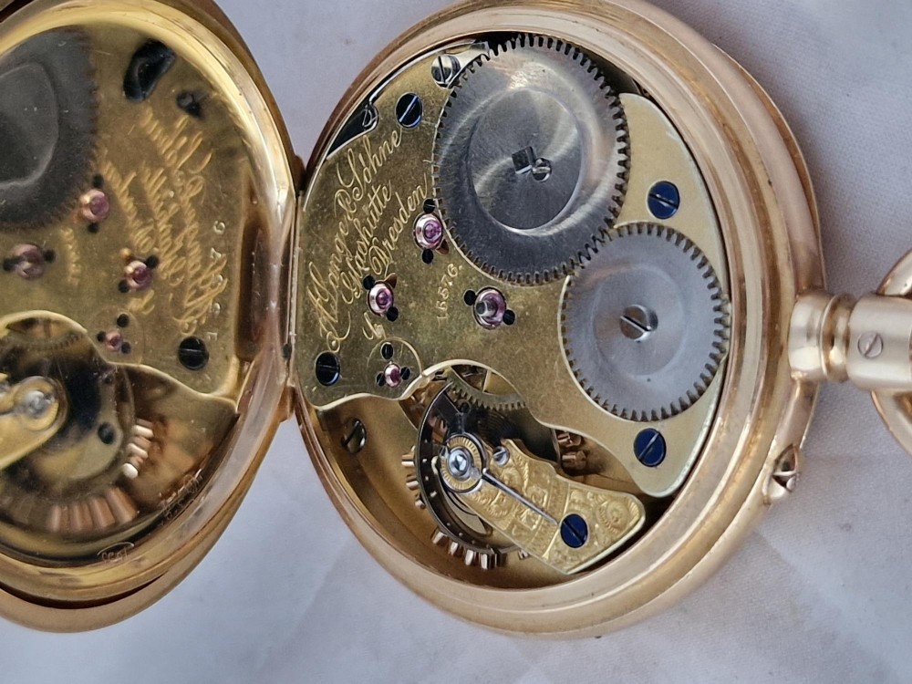 An open-face 18ct yellow gold pocket watch featuring a white enamel dial with black Roman numerals and a subsidiary seconds dial. View V