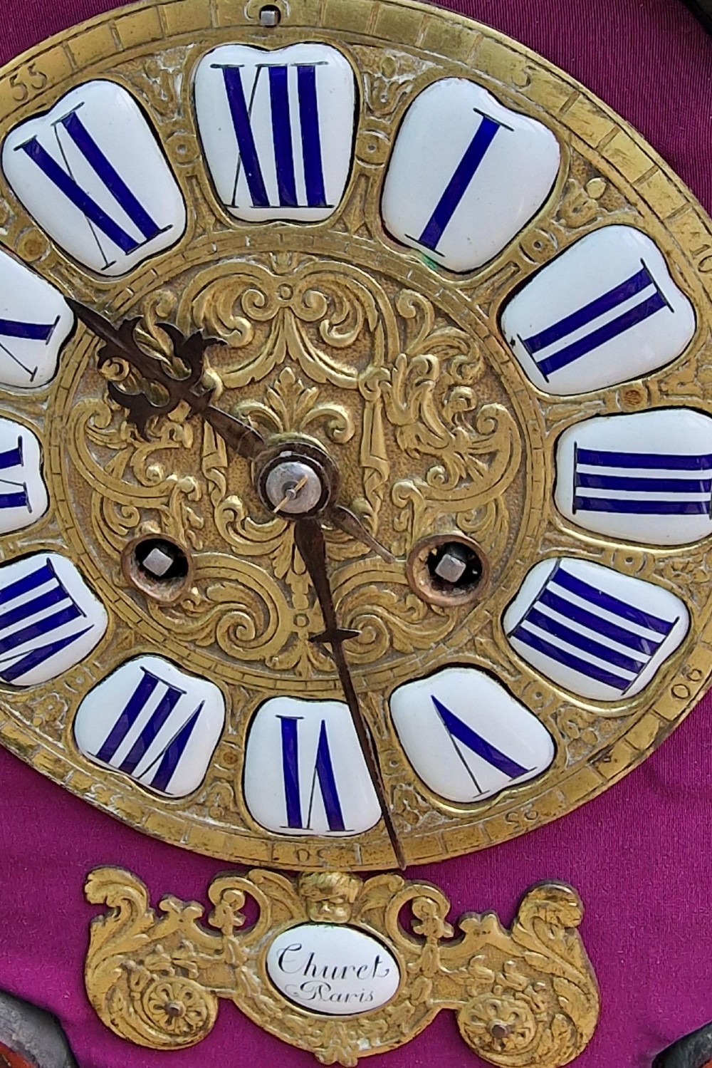 A red tortoiseshell and gilt bronze mantel clock featuring enamel Roman numeral cartouches and cast finials. View IV
