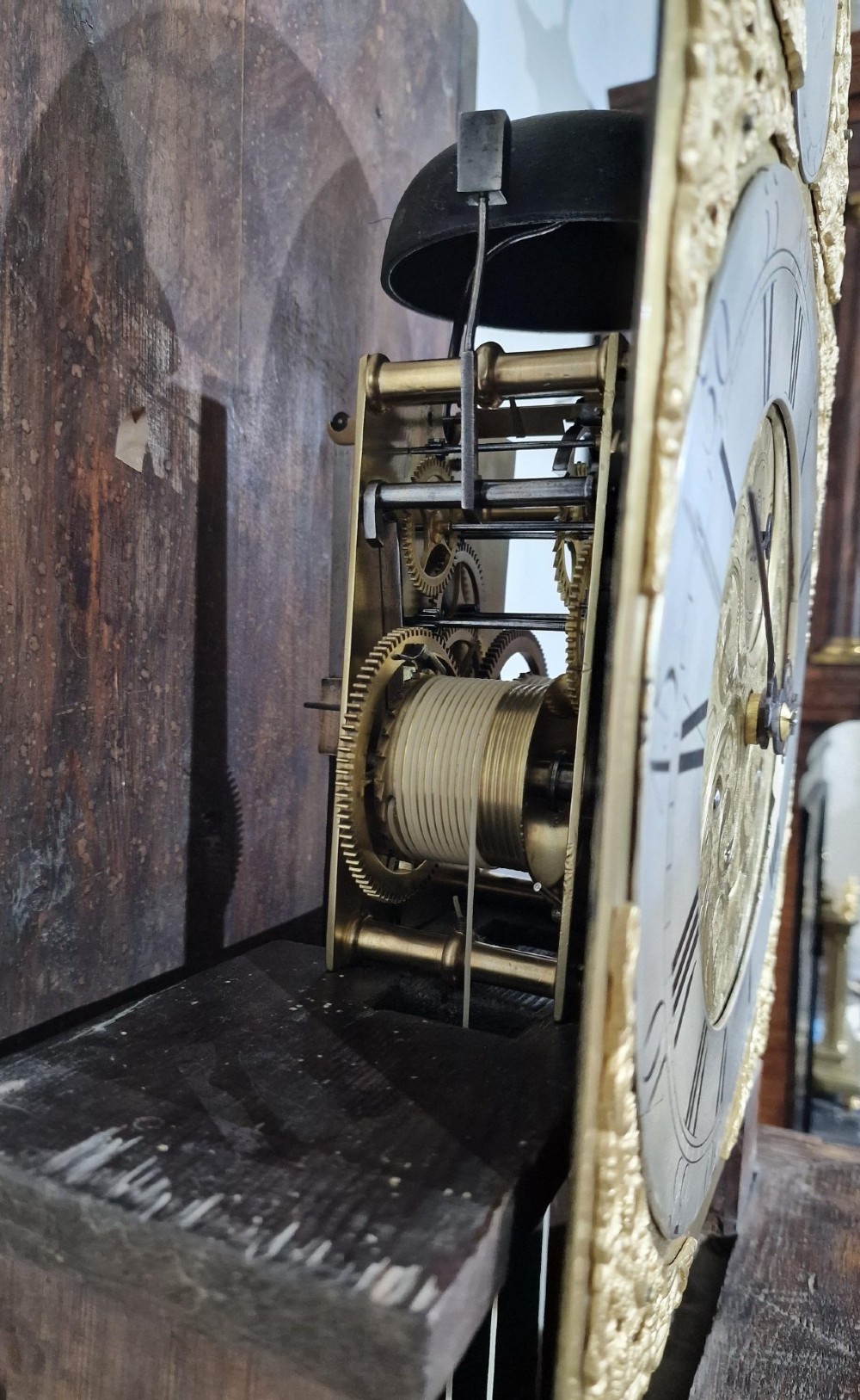 A Georgian oak longcase clock featuring a swan-neck pediment with brass eagle finials and an arched brass dial. View VI