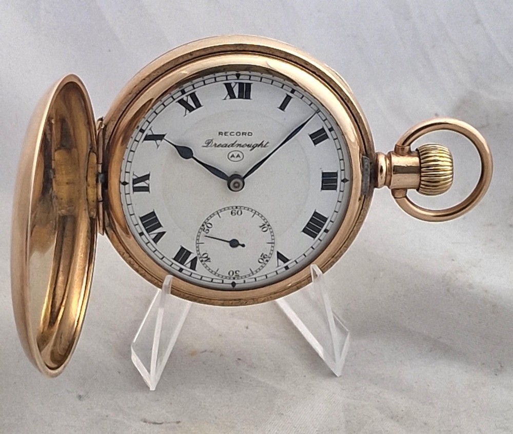 A gold full hunter pocket watch with an open outer case revealing a white enamel dial with black Roman numerals and a subsidiary seconds dial.