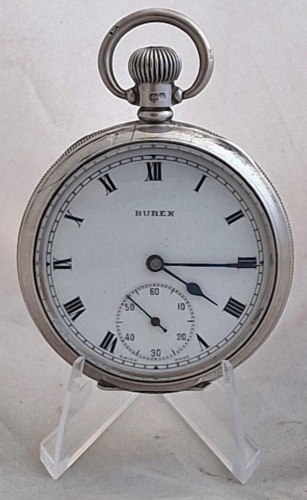 An open-face silver Buren pocket watch featuring a white enamel dial with Roman numerals and a small seconds sub-dial.