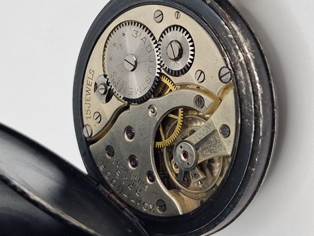 An open-face antique pocket watch with a white enamel dial, black Roman numerals, sub-seconds dial, and a silver metal case with a gold-toned crown. View III