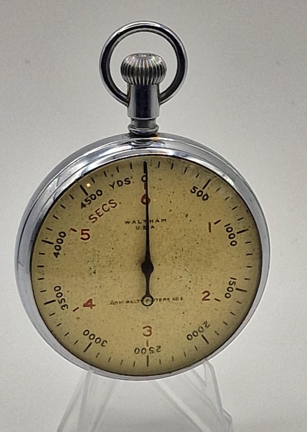 A Second World War era Royal Navy Waltham submarine stopwatch featuring a chrome-plated metal casing and a cream dial with red and black numerals.
