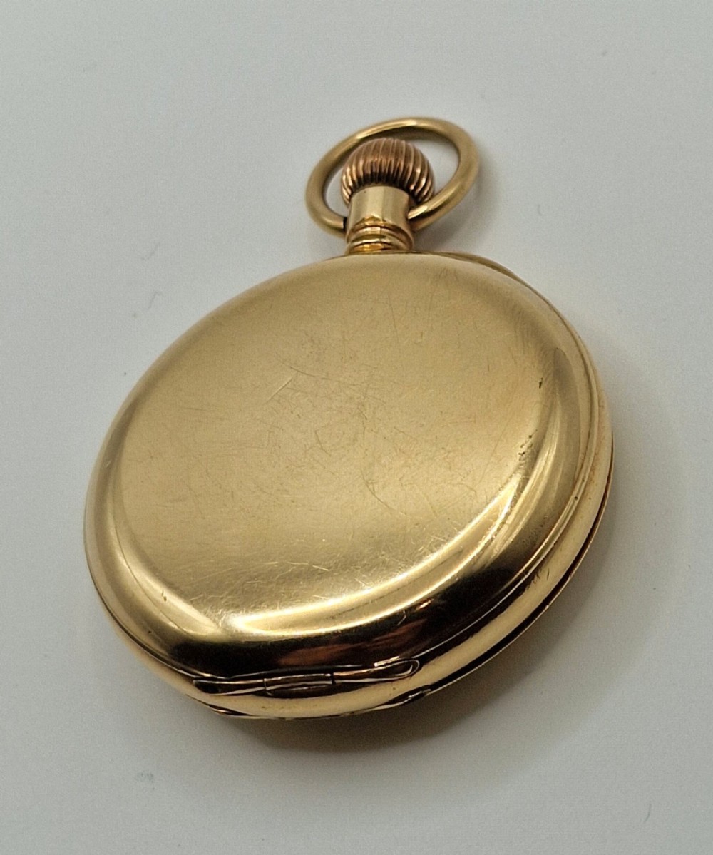 An open gold half hunter pocket watch displaying a white enamel dial with black Roman numerals and a small sub-seconds dial at six oclock. View III