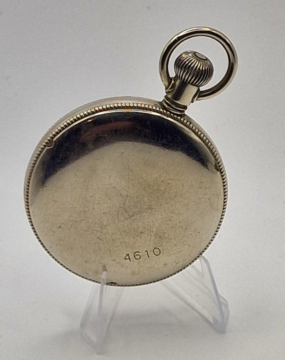 An open-face vintage military pocket watch featuring a black dial, Arabic numerals, luminous hands, a subsidiary seconds sub-dial, and a nickel case with top loop. View III