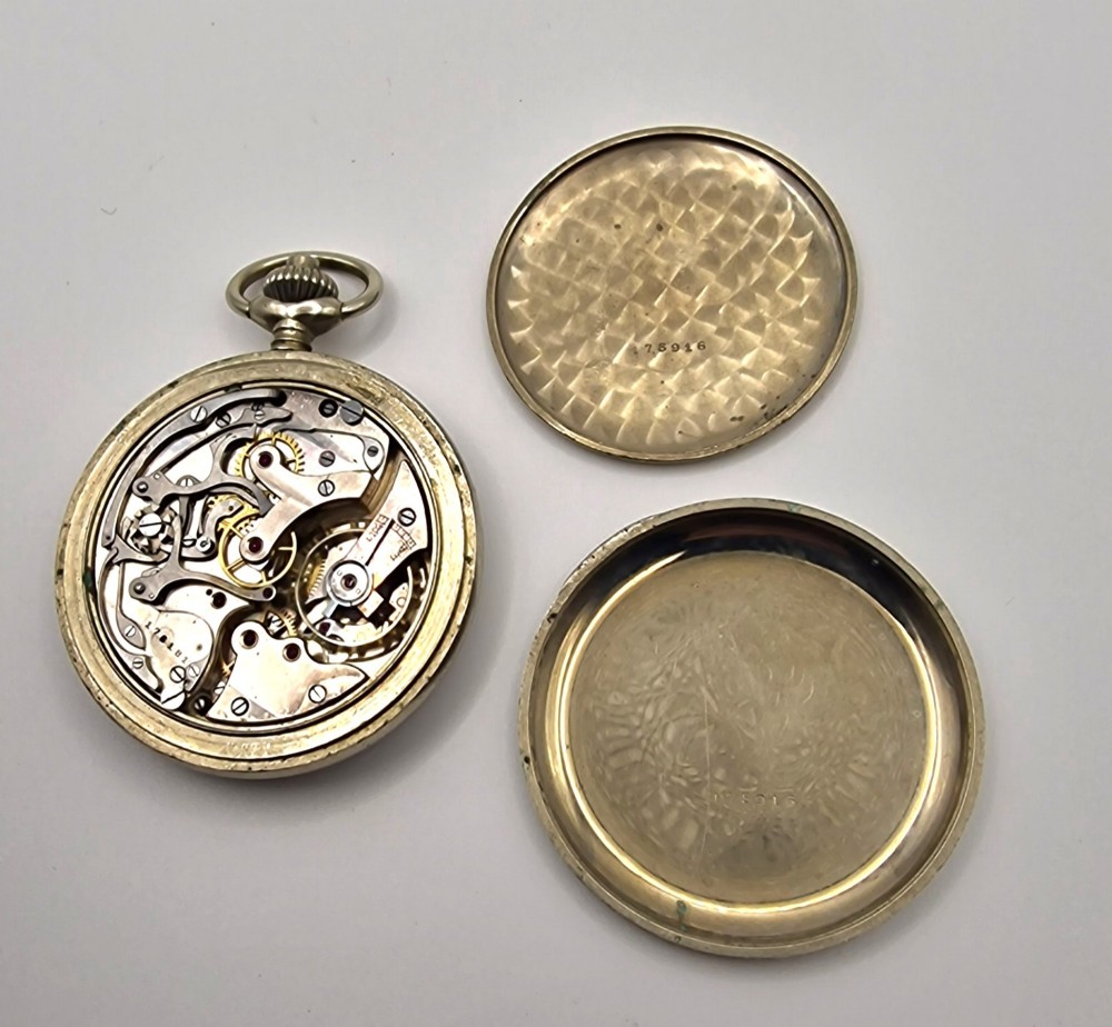 A vintage military chronograph pocket watch featuring a silver-tone metal case, a black dial with luminous Arabic numerals, two sub-dials, and an onion-style crown. View III