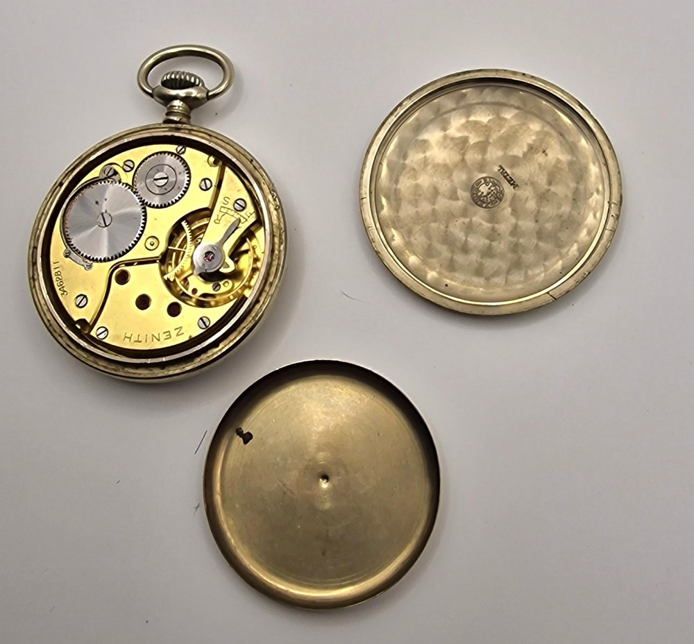 A Zenith open-face military pocket watch featuring a black dial, white Arabic numerals, a subsidiary seconds dial, and a silver-tone metal case. View II