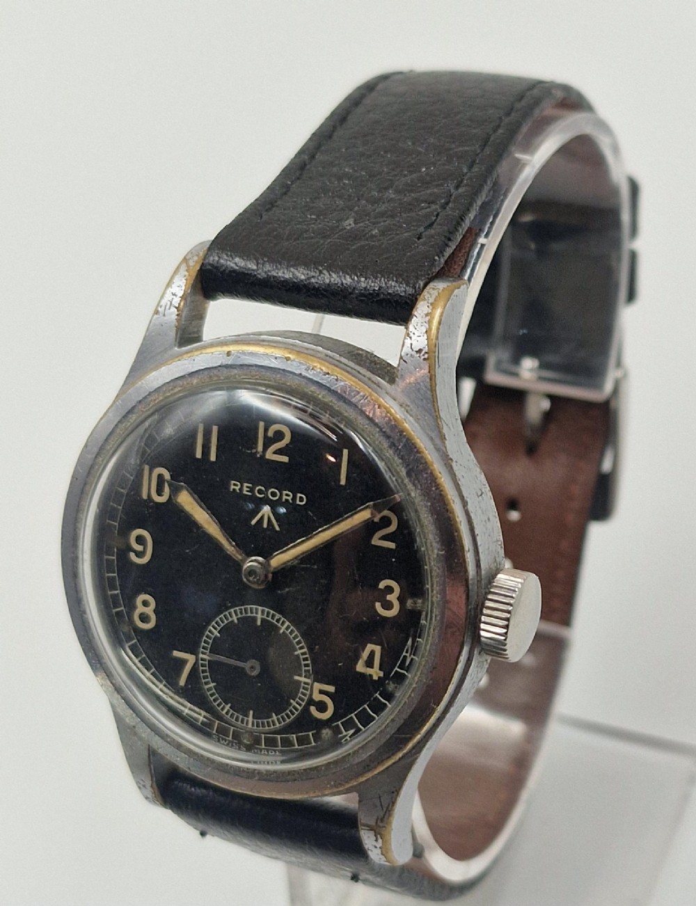 A 1940s Record military wristwatch featuring a black dial with luminous numerals, broad arrow mark, sub-seconds dial, and a black leather strap. View III