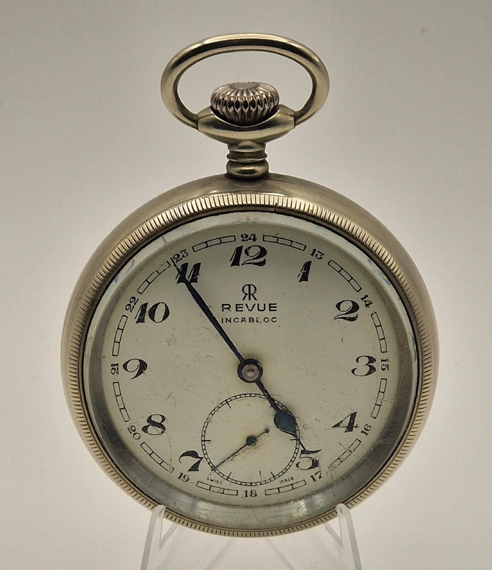 An open-face silver-toned railway pocket watch with a white dial, blued steel hands, Arabic numerals, and a small seconds sub-dial.