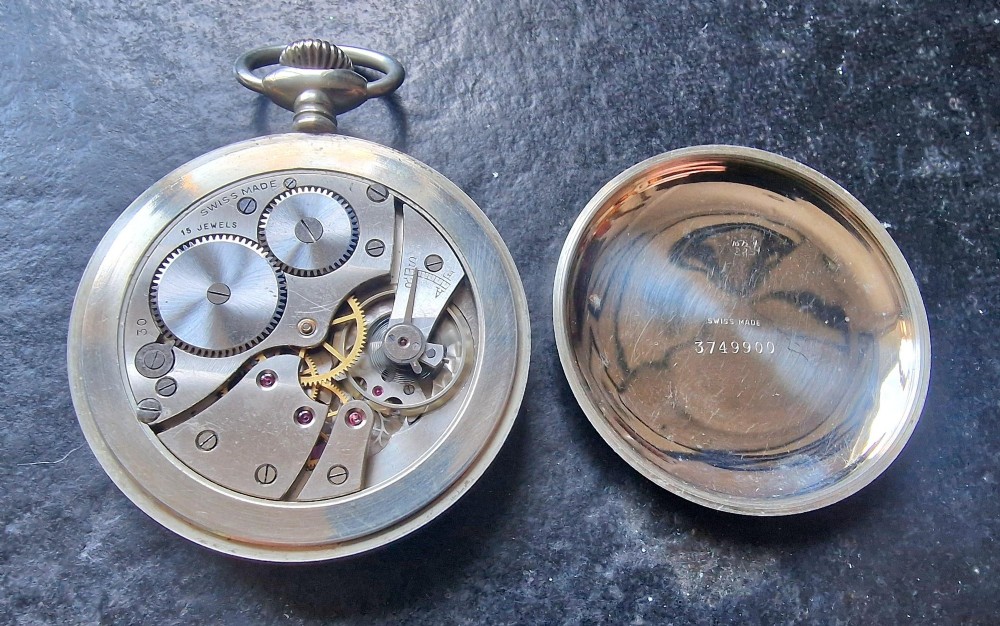 An open-face silver-toned railway pocket watch with a white dial, blued steel hands, Arabic numerals, and a small seconds sub-dial. View III