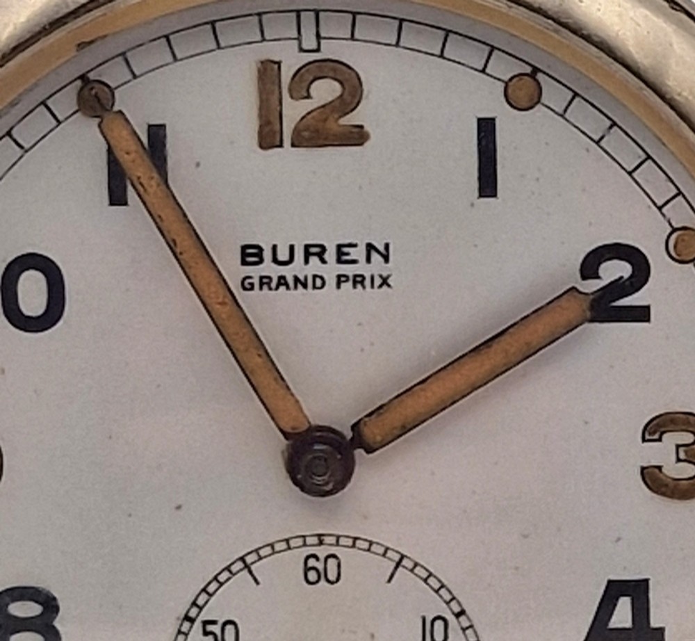 A vintage Buren Grand Prix Swiss pocket watch featuring a white dial, black Arabic numerals, luminous hands, a sub-seconds dial, and a silver-tone chrome case. View IV